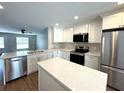 Bright kitchen with stainless steel appliances, central island, and white cabinetry at 3120 Oleander Dr, Indian Lake Estates, FL 33855