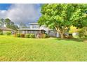 A spacious screened in porch looks out onto a large back yard with a large tree at 329 Hamilton Shores Ne Dr, Winter Haven, FL 33881