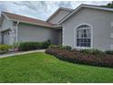 Well-manicured lawn with lush landscaping leading to the front entrance of the home at 4063 Birkdale Dr, Lake Wales, FL 33859
