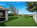 A backyard featuring manicured lawn with trees and shrubs, and a waterfront view at 4099 Island Lakes Dr, Winter Haven, FL 33881
