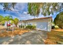 A well-kept, light yellow single-story home featuring an attached garage and an inviting driveway at 4229 Nandina St, Lake Wales, FL 33898