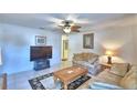 Cozy living room with tile flooring, ceiling fan, comfortable couches and a decorative palm tree rug at 4229 Nandina St, Lake Wales, FL 33898