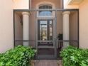 Inviting front entrance with a screened-in porch, stone pillars, and double glass doors at 4313 Heath Land Ln, Lake Wales, FL 33859