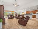 Spacious living room with high ceilings, tile flooring, and comfortable leather furniture at 4313 Heath Land Ln, Lake Wales, FL 33859