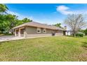 This home has an attached garage with ample parking space, complemented by a lush green lawn at 5020 Broadmore Dr, Auburndale, FL 33823