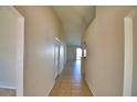 Long hallway featuring tile flooring and neutral walls leading toward a bright living space at 509 Heather Glen Dr, Winter Haven, FL 33884