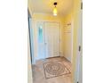 The entryway features yellow walls, a white door, a mosaic-patterned tile inset, and coat hooks at 579 Saint Andrews Rd, Winter Haven, FL 33884