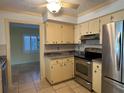 Kitchen with stainless steel appliances, two-tone cabinets, and a view into the dining room at 579 Saint Andrews Rd, Winter Haven, FL 33884