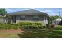 The front exterior of a single-story home with a green lawn and decorative foliage at 614 Chatham Dr, Lakeland, FL 33803