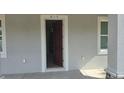 Front door leads into the home, framed by white trim and flanked by windows for natural light at 615 Avenue S Ne, Winter Haven, FL 33881