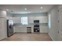 Kitchen with stainless steel appliances, white cabinets, and a window for ample light at 615 Avenue S Ne, Winter Haven, FL 33881