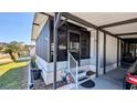Exterior showcasing a screened front porch, white railings, and a convenient carport at 6450 Hollyberry Ne Ln, Winter Haven, FL 33881
