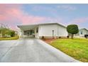 Inviting single-story home with a long driveway, carport, and manicured lawn at 6510 Oak Hammock Ln, Winter Haven, FL 33884