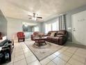 Cozy living room featuring tile floors, a large mirror, and comfortable seating with natural light at 799 W Lake Otis Dr, Winter Haven, FL 33880