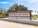 Entrance sign for Walk In Water Lake Estates, set on a concrete base with a red and white roof at 8947 Oakwood Dr, Lake Wales, FL 33898