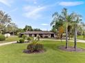 Well-maintained ranch-style home with a lush green lawn, mature trees, and landscaping at 8947 Oakwood Dr, Lake Wales, FL 33898