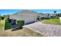 Side view of a home with a patterned brick driveway leading to a two-car garage at 916 Balmoral Dr, Davenport, FL 33896