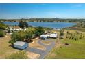 Aerial view of property showcasing a waterfront home, detached garage, and lake access at 100 Masterpiece Rd, Lake Wales, FL 33898