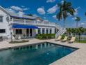 Backyard pool with lounge chairs and a covered balcony overlooking serene water views at 125 E Graham Park Dr, Haines City, FL 33844