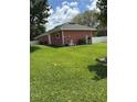 Spacious backyard with lush green grass, exterior of home, and storage components at 1403 Hidden Creek Ln, Winter Haven, FL 33880