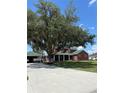 Charming brick home with a covered porch, spacious lawn, mature trees, and a welcoming driveway at 1403 Hidden Creek Ln, Winter Haven, FL 33880