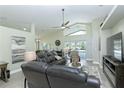 Bright living room boasts vaulted ceiling, fan, tile floors, and comfortable leather seating at 1942 Bermuda Pointe Dr, Haines City, FL 33844