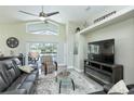 Open living room with high ceiling, tile floors, TV, modern furnishings and patio access at 1942 Bermuda Pointe Dr, Haines City, FL 33844
