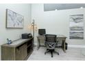 Well-lit home office featuring tiled floors, a modern desk, and decorative artwork at 1942 Bermuda Pointe Dr, Haines City, FL 33844