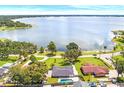 Aerial view of home with pool, surrounded by trees and a scenic lake view at 2096 Lake Ariana Blvd, Auburndale, FL 33823