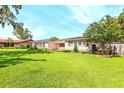 Well-manicured front yard with lush green grass and landscaping in front of single-story home at 2096 Lake Ariana Blvd, Auburndale, FL 33823