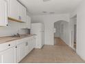Bright, white kitchen featuring wood counters and stainless steel appliances, with an opening leading to the rest of the home at 2301 Freemason St, Lakeland, FL 33801