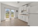 Bright kitchen featuring white cabinets, a stainless steel sink, and double doors with an exterior view at 2301 Freemason St, Lakeland, FL 33801