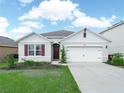 Well maintained home featuring manicured landscaping, a two-car garage and an inviting entrance at 3862 Whitney Way, Haines City, FL 33844