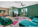 Stylish living room featuring vibrant green walls, modern furnishings, and abundant natural light at 3862 Whitney Way, Haines City, FL 33844