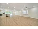 An open-concept living space featuring new floors, modern lighting, and large windows at 409 Greenfield Rd, Winter Haven, FL 33884