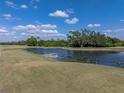 Scenic view of a tranquil pond surrounded by a lush green golf course and mature trees at 4279 Ashton Club Dr, Lake Wales, FL 33859