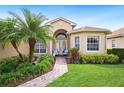 Close up of beautiful home exterior with manicured lawn, brick pathway, and a charming entry way at 5200 Pebble Beach Blvd, Winter Haven, FL 33884