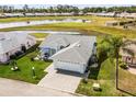 Aerial view of a beautiful home with a manicured lawn, a lake view, and a golf course in the background at 530 Eastlake Dr, Haines City, FL 33844