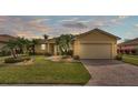 Charming single-story home with a well-manicured lawn, paved driveway, and lush tropical landscaping at 5341 Hogan Ln, Winter Haven, FL 33884