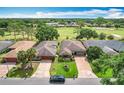 Aerial shot of homes showcasing well-maintained yards and proximity to a lush golf course, highlighting the community's appeal at 571 Saint Andrews Rd, Winter Haven, FL 33884