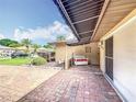 Inviting outdoor seating area with brick flooring and awning, perfect for relaxation and enjoying the property's curb appeal at 571 Saint Andrews Rd, Winter Haven, FL 33884