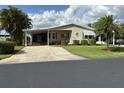 Inviting single-story home with a covered carport, landscaped front yard, and well-maintained exterior at 6107 Grand Oaks Se Dr, Winter Haven, FL 33884