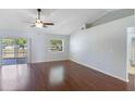 Vaulted ceiling living room with hardwood floors, ceiling fan, slider doors to the lanai, and a view of the bathroom at 6560 Horizon Point Dr, Lakeland, FL 33813