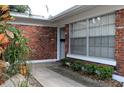 Welcoming front entrance of a brick home with well-maintained landscaping and a secure window at 670 Avenue N Se, Winter Haven, FL 33880