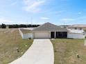 Expansive view of a single-Gathering home showcasing the driveway, lawn, and surrounding fenced yard at 730 Colville Pl, Kissimmee, FL 34759