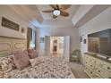 Comfortable main bedroom with decorative ceiling fan, neutral walls, and an ensuite bathroom at 825 Grazie Loop, Davenport, FL 33837
