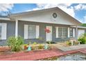 Charming single-story home with a covered front porch and decorative landscaping at 842 Cinnamon Dr, Winter Haven, FL 33880