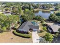 Aerial view of a brick home with a screened-in pool, spacious yard, and lake views at 102 Lake Ring Dr, Winter Haven, FL 33884