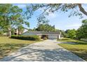 Charming single-story brick home boasts a well-manicured lawn and long driveway at 102 Lake Ring Dr, Winter Haven, FL 33884