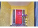 Inviting entryway with a bright red front door and decorative flower display at 103 Lake Thomas Dr, Winter Haven, FL 33880